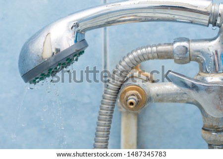 Broken faucet with shower in bathroom