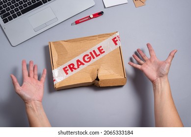 Broken fragile parcel, torn cardboard box on office desk