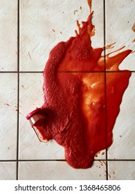 Broken Glass Bottle Of Bright Red Tomato Sauce On White Tile Floor With Roll Of White Paper Towel, Scene From Above Looking Down, Concept Accident Spill Cleanup, Kitchen Cooking