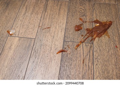 Broken Glass Bottle Of Bright Red Tomato Sauce On White Tile Floor With Roll Of White Paper Towel, Scene From Above Looking Down, Concept Accident Spill Cleanup, Kitchen Cooking.