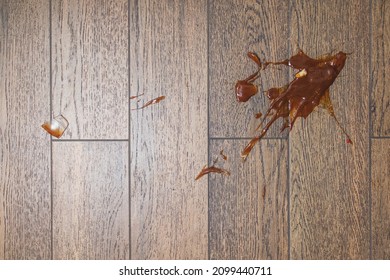 Broken Glass Bottle Of Bright Red Tomato Sauce On White Tile Floor With Roll Of White Paper Towel, Scene From Above Looking Down, Concept Accident Spill Cleanup, Kitchen Cooking.