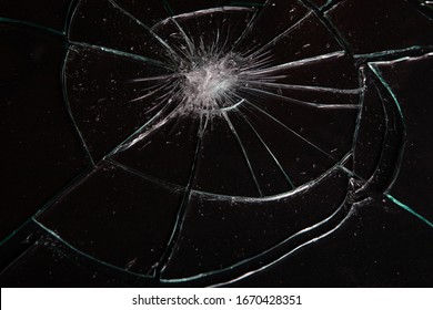 Broken glass with cracks on black background