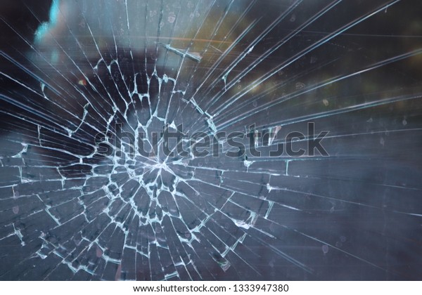 broken glass. Criminal incident at\
the bus stop. Hole and cracks in the glass of a city bus stop.\
Cracked glass Texture. Cracked glass with a hole from a\
bullet
