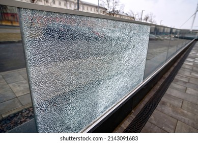 Broken glass fence. Damaged glass fence with banisters. Broken guard rail on office terrace. Steel railing with glass panel, cracks on broken tempered glass. Vandalism concept