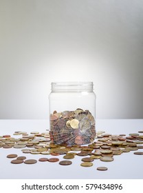 Broken Glass Jar With A Lot Of Coins