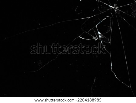 A broken glass on a deep black background, with a hole in the top right corner. Useful texture for overlays.
