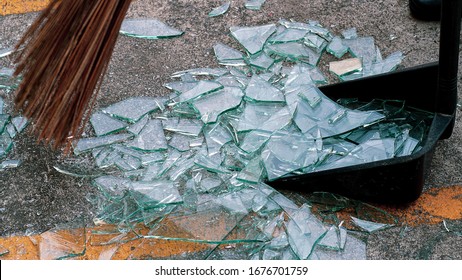 Broken Glass On The Floor With A Broom And Dustpan.