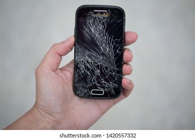 Broken glass screen smartphone in hand.Hand holding mobile phone with broken screen.
Smartphone with cracked display in hand.Hand hold the cellular.