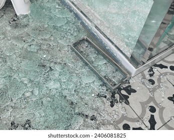Broken glass shower door with chrome handle in a tiled bathroom
