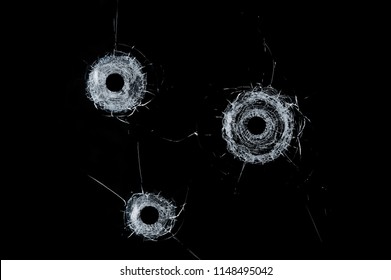 Broken glass triple bullet holes in glass isolated on black