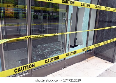 Broken glass window on retail store front from criminals looting and rioting in Manhattan New York during racial protests