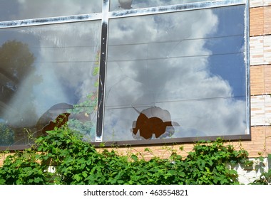 Broken Glass Window Reflecting Cloudy Sky. A House Window With A Broken Window Pane Outdoor.