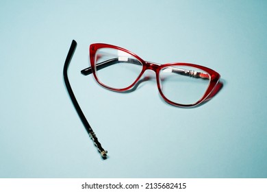 Broken Glasses Isolated On Gray Background. Red Plastic Frame  