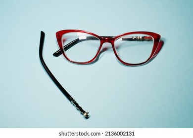 Broken Glasses Isolated On Gray Background. Red Plastic Fram