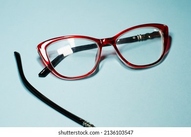 Broken Glasses Isolated On Gray Background. Red Plastic Frame  