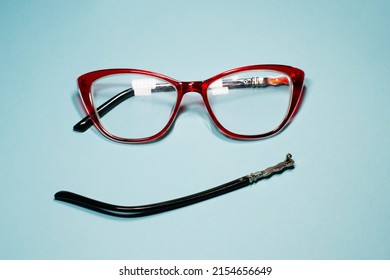 Broken Glasses Isolated On Gray Background. Red Plastic Frame