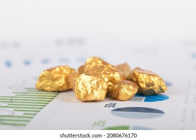 Broken gold scattered on financial documents - Shutterstock ID 2080676170