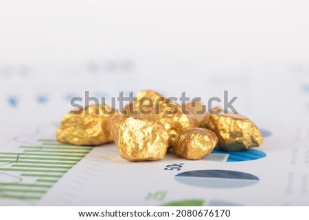 Broken gold scattered on financial documents