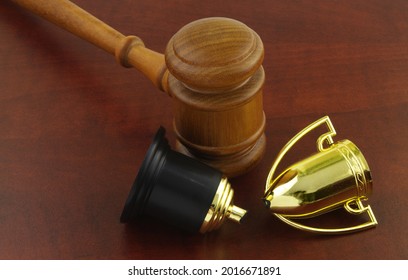 Broken Golden Trophy Cup And Judge Gavel On Wooden Background