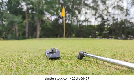 Broken Golf Putter Isolated Near The Golf Hole.