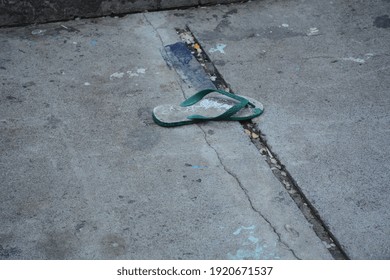 Broken Green Rubber Flip Flop. Probolinggo City, East Java, Indonesia, February 2021.