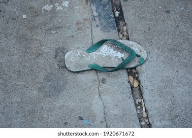 Broken Green Rubber Flip Flop. Probolinggo City, East Java, Indonesia, February 2021.