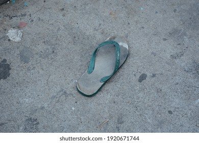 Broken Green Rubber Flip Flop. Probolinggo City, East Java, Indonesia, February 2021.