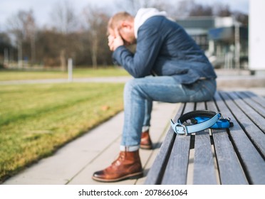 Broken with grief man dog owner is grieving sitting on a bench with the lovely pet collar and deep weeping about animal loss. Home pets relatives and love concept.