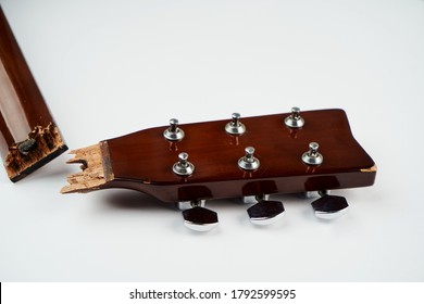 Broken Guitar Neck On A White Background With Copy Space. Broken Acoustic Guitar Headstock, Close-up. Guitar Repair And Service 