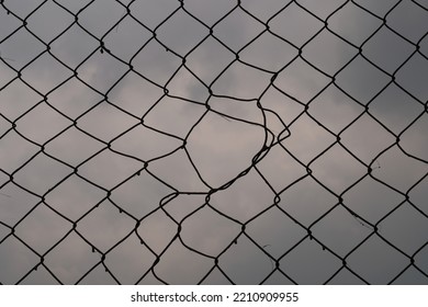 Broken Harmonica Wire Fence. Silhouette View