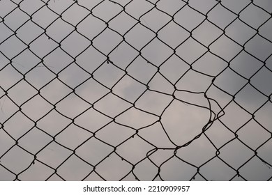 Broken Harmonica Wire Fence. Silhouette View