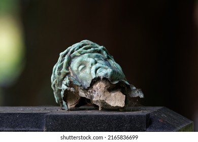 Broken Head Of A Crucifix On A Tombstone