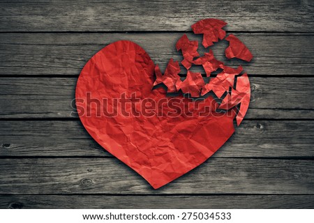 Broken heart breakup concept separation and divorce icon. Red crumpled paper shaped as a torn love on old wood symbol of medical cardiovascular health care problems due to illness