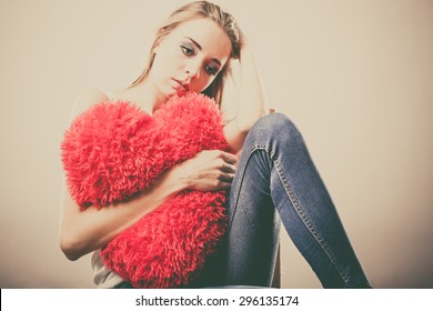 Broken Heart Love Concept. Sad Unhappy Woman Hugging Red Heart Pillow Closeup