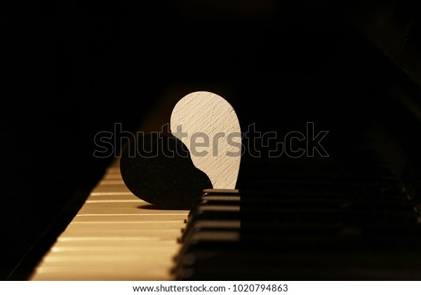 broken heart on piano keys, divided heart, black\
and white
