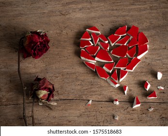 Broken heart with broken red glass and couple red rose dry on wood background for break my heart love, pain, sad. Accompanying sadness article. heart couple or poster. valentine concept.