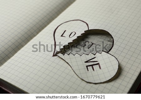 Broken heart with words LOVE and LOST in notebook, closeup. Relationship problems concept