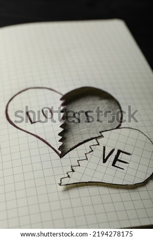 Broken heart with words LOVE and LOST in notebook on table, closeup. Relationship problems concept