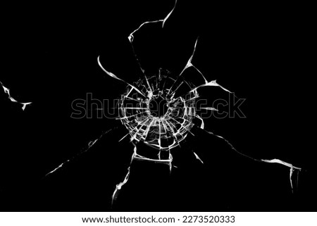 Broken hole in glass black background.