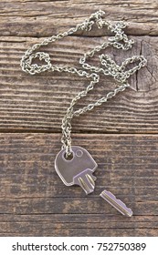 Broken House Key On Chain On Wooden Background 