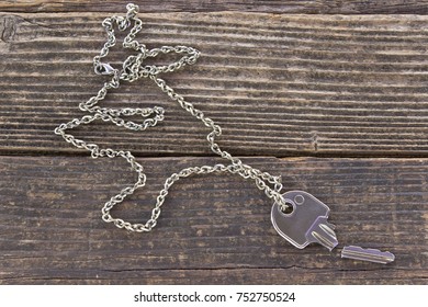 Broken House Key On Chain On Wooden Background 