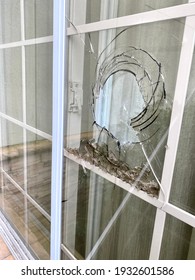 Broken House Window On Exterior, With Glass Pieces Stuck Inside.