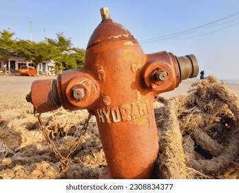 a broken hydrant lying in the dock area looks crooked and rusty