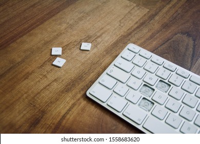 Broken Keyboard With Missing Keys On Wooden Desk