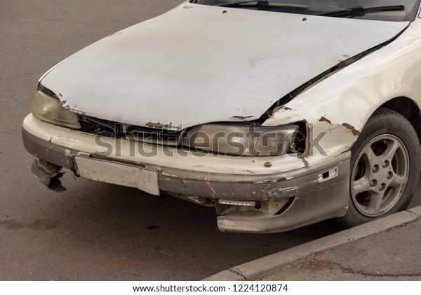 broken lamp headlight and bumper car scratched with\
deep damage to grey\
paint