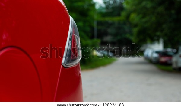 The broken lamp of the red\
sedan