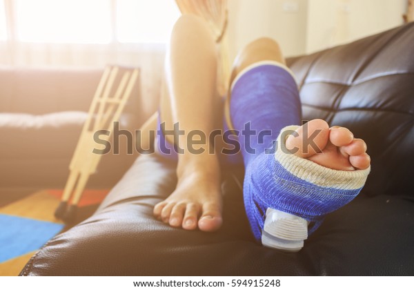 broken leg in a plaster cast with soft-focus in the\
background. over light