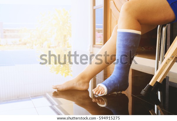 broken leg in a plaster cast with soft-focus in the\
background. over light