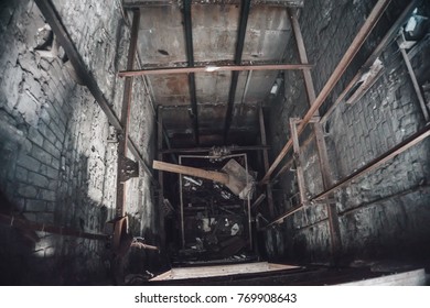 Broken Lift or elevator shaft or well in abandoned industrial ruined factory, toned