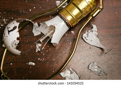 Broken Light Bulb In Fixture On Table Top